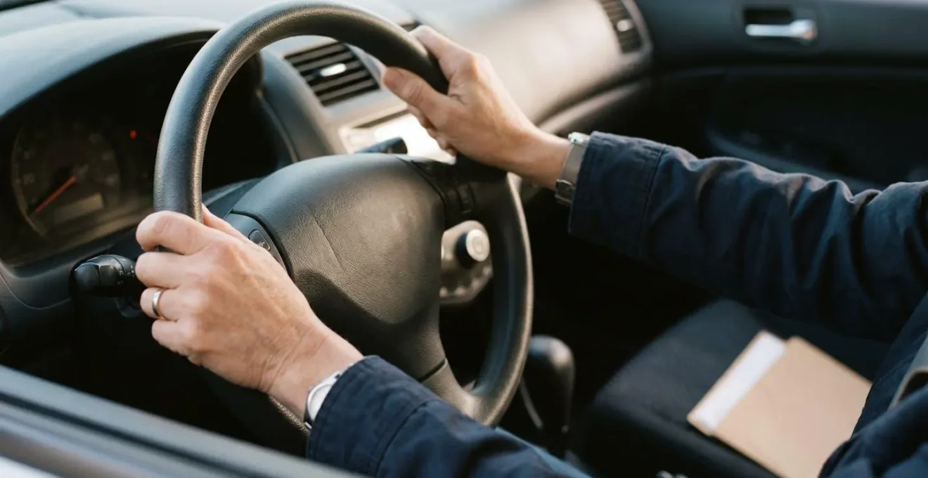 Conducteur satisfait au volant d'un véhicule économique avec documents d'assurance